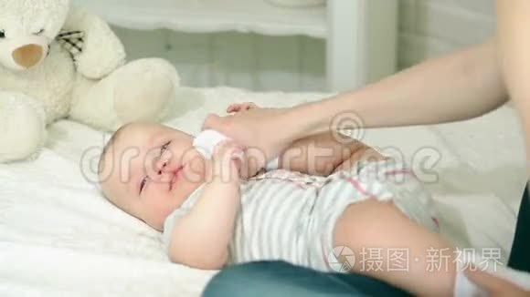 妈妈和孩子玩。 年轻的家庭。 六个月的孩子和母亲。 快乐的妈妈。 妈妈和儿子玩得很开心。 孩子笑了。