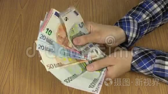 手拿着不同钞票的欧元货币风扇。 4K