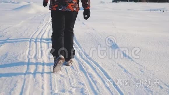 团队合作。 男游客摄影师冬天乘三脚架爬山顶山顶山顶群去下雪