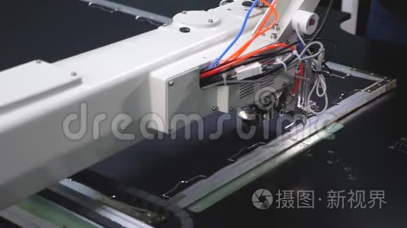 机器人在裁剪生产线上工作。 电脑控制缝纫机.. 针绣图案