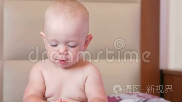 一个英俊的婴儿早餐时在床上吃苹果。 他咬掉一块，放进嘴里