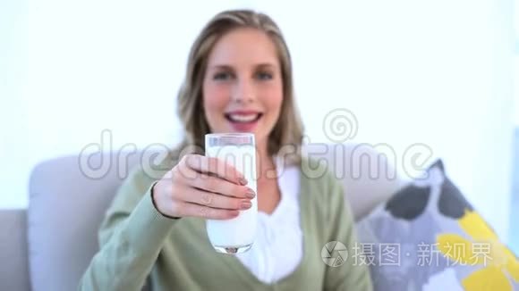 女人把她的一杯牛奶拿给镜头看视频
