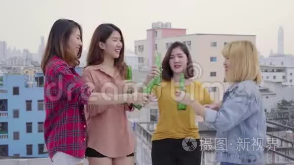 一群年轻的亚洲女性在日落都市派对上，随着DJ演奏的音乐翩翩起舞，举起双臂。