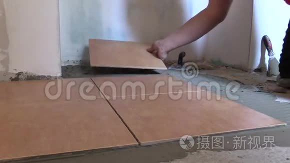 用手把瓷砖放在家门口的水泥胶上