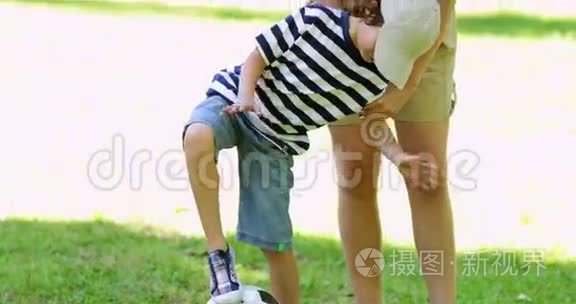 妈妈和她的小儿子在踢足球