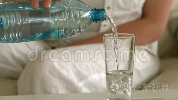 年轻女子坐在沙发上倒着一杯水