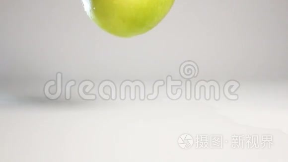 绿苹果落在白色的表面上视频