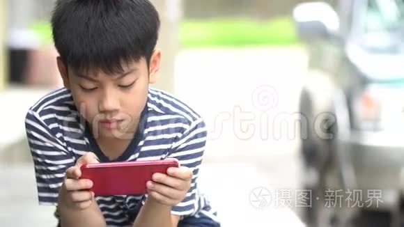 亚洲男孩在路边用智能手机视频