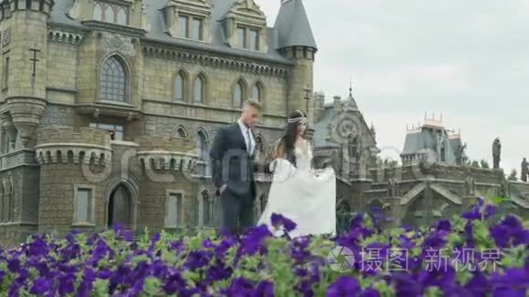 快乐美丽的新娘和新郎走在城堡附近