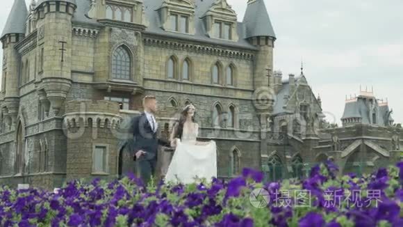 快乐美丽的新娘和新郎走在城堡附近