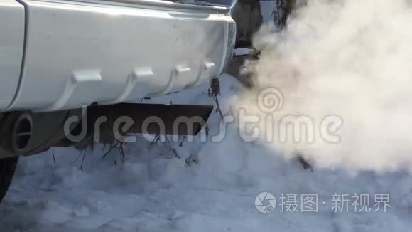 消声器运转车产生的废气.. 在冬季道路上行驶的汽车的轮子。