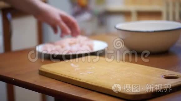 女人烹制的新鲜生肉在餐桌上与肉锤在家庭厨房。 慢动作