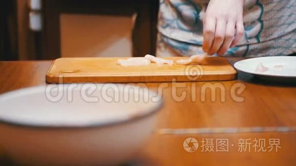 女人烹制的新鲜生肉在餐桌上与肉锤在家庭厨房。 慢动作