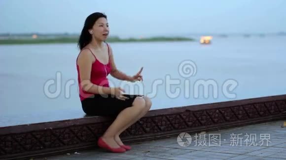 亚洲女商人下班后在河边听音乐