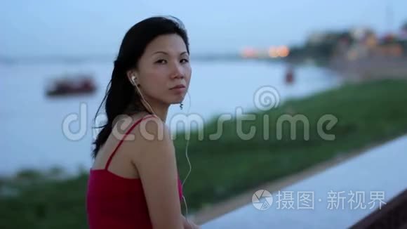 亚洲女商人下班后在河边听音乐