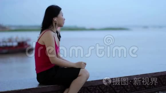 亚洲女商人下班后在河边听音乐