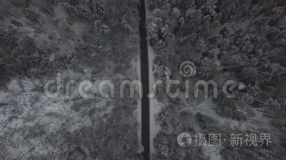 通过白雪森林无人驾驶飞机观看冬季道路上的汽车交通