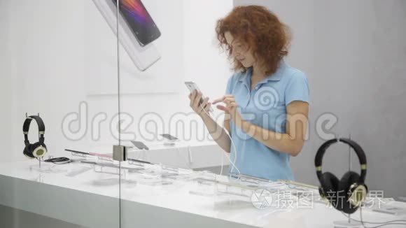 女人在商店里选择智能手机视频