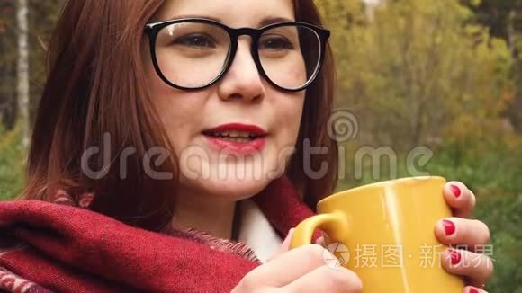 年轻女子从杯子里喝热茶以保暖视频