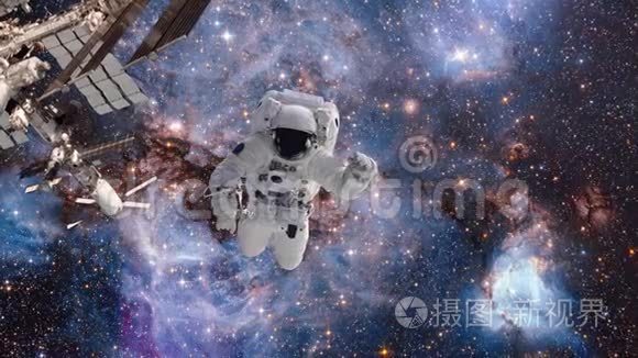 一个星系和一群恒星背景下在外层空间的宇航员。 宇航员在零重力下盘旋