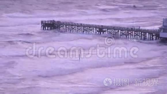 钓鱼码头上的人们看着海浪和风吹