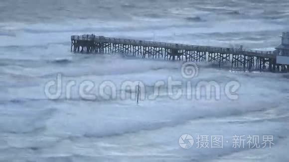 钓鱼码头上的人们看着海浪和风吹