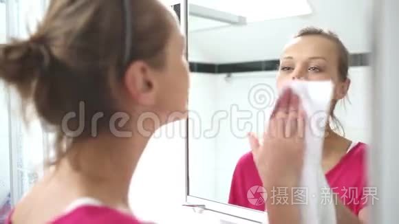 年轻女子在擦镜子