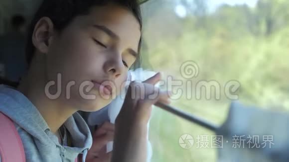 悲伤的女孩看着火车的生活方式窗口。 旅游运输铁路概念。 少女错过了在一个