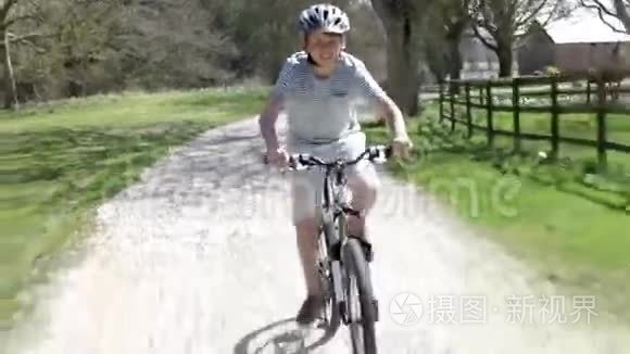 少年骑自行车沿乡村赛道行驶视频