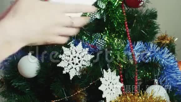女孩的手把礼物送给靠近圣诞树的朋友
