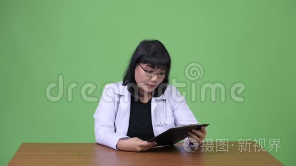 美丽的亚洲女医生阅读剪贴板视频