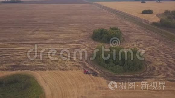 空中在耕地上向射击。一辆红色拖拉机在秋天开垦田地