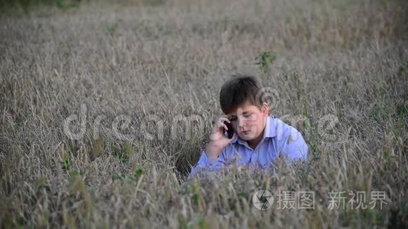 少年在草地上使用智能手机