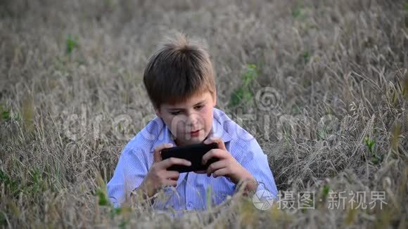 少年在草地上使用智能手机