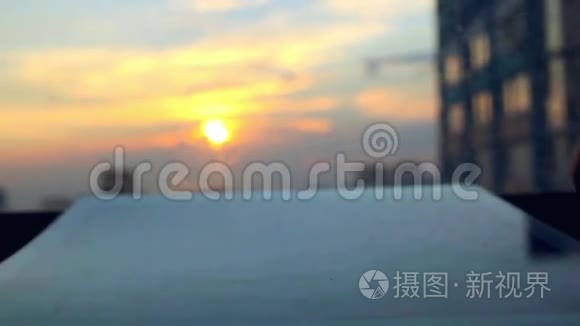 女人在模糊的夕阳天空上用平板电脑