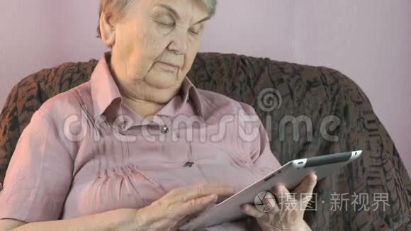 80多岁的老妇人手持银制平板电脑
