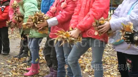 孩子们手里握着黄色的树叶