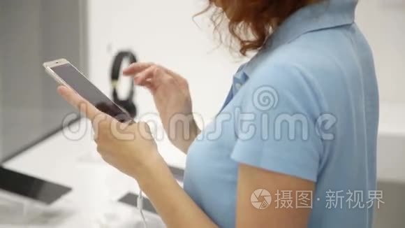 女人在商店里选择智能手机视频