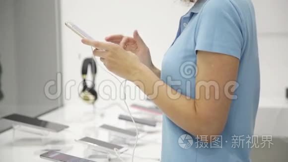 女人在商店里选择智能手机视频