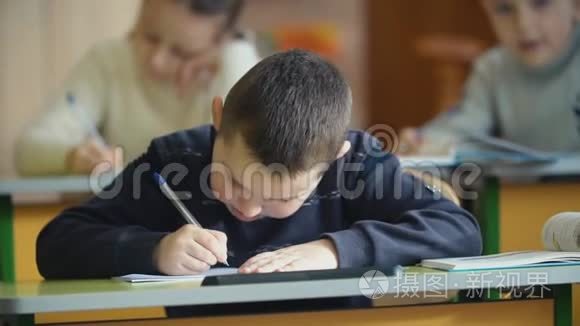 孩子们坐在书桌前写字视频