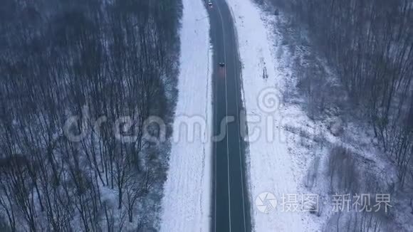 冬季穿过冬季森林的道路上的交通鸟瞰图