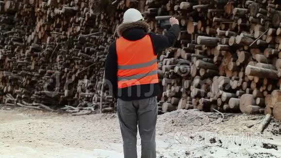 工程师在冬天在一堆圆木附近拍摄