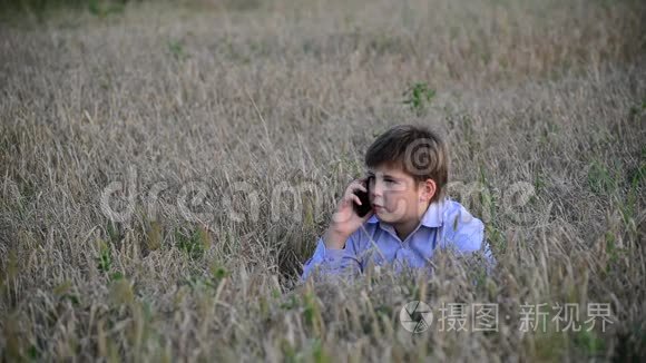 少年在草地上使用智能手机