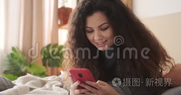 快乐的女人在床上用手机视频