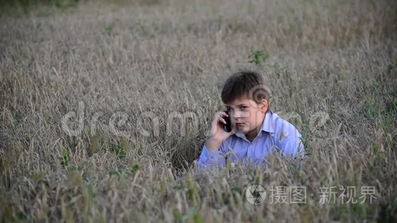 少年在草地上使用智能手机视频