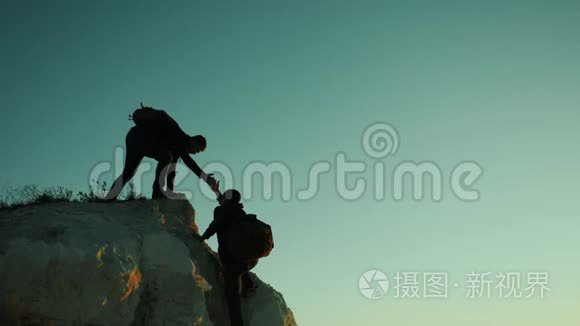 两个男子协同游客爬上一座山。 徒步旅行者徒步旅行冒险登山日落攀登