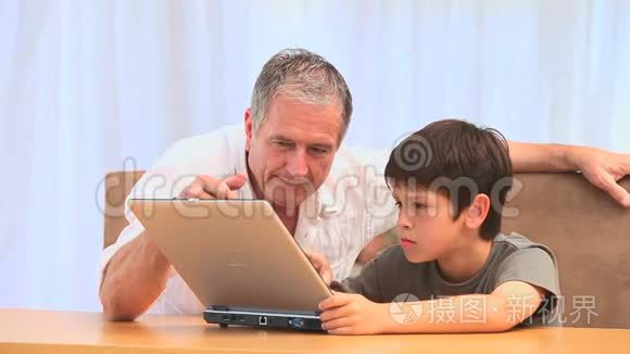 爷爷和他孙子用笔记本电脑