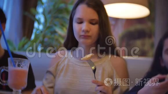 孩子们，女孩，一家人，在咖啡馆里吃披萨。 青少年在咖啡厅慢动作视频中吃快餐