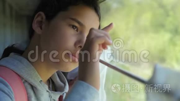 生活方式悲伤的女孩看着火车窗口。 旅游运输铁路概念。 十几岁的女孩错过了在