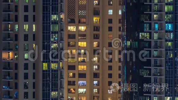 在多层现代玻璃和金属住宅建筑的发光窗口在夜间时间推移。